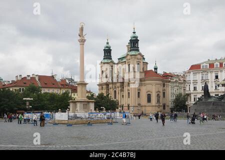 Colonna Mariana (Mariánský sloup) nella Piazza della Città Vecchia (Staroměstské náměstí) a Praga, Repubblica Ceca. La colonna originale del 1652 fu distrutta nel novembre 1918, poco dopo la proclamazione dell'indipendenza della Cecoslovacchia dall'Impero austro-ungarico. La copia della colonna mariana fu eretta nello stesso luogo il 4 giugno 2020. La Chiesa di San Nicola (Kostel svatého Mikuláše) è vista sullo sfondo. Foto Stock