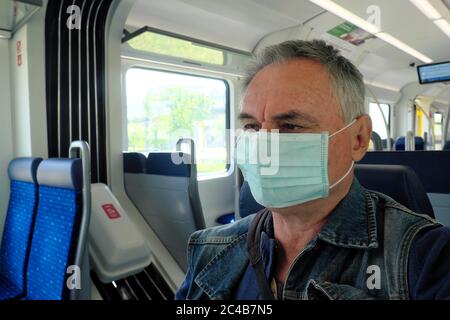 Uomo con maschera nel treno suburbano, crisi di Corona, Monaco, Baviera, Germania Foto Stock