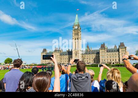 I visitatori fotografano il cambio della guardia di fronte al Canadian Parliament Building Center Block, Parliament Hill, Ottawa, Ontario, Canada Foto Stock