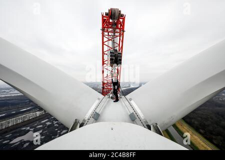 Assemblaggio di una centrale eolica, un assemblatore per centrali eoliche sta lavorando ad un'altezza di 100 metri durante l'assemblaggio dell'anello del rotore con marciume Foto Stock