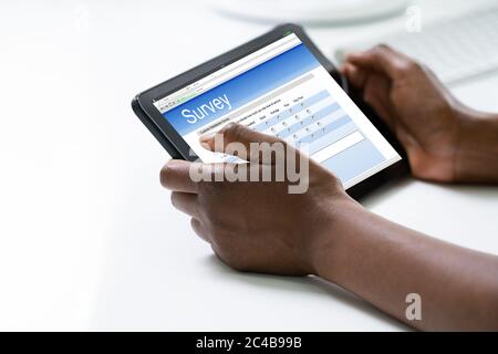 Sondaggio African Woman Filling o modulo su Tablet computer Foto Stock