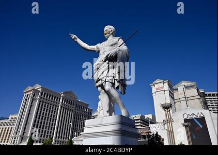 Las Vegas, Nevada, Stati Uniti. 25 Giugno 2020. Una statua di Julius Caesar di fronte al Caesars Palace lungo la Strip di Las Vegas indossa una maschera facciale tra la diffusione del coronavirus il 25 giugno 2020 a Las Vegas, Nevada. Mercoledì, Nevada Gov. Steve Sisolak ha firmato una direttiva che impone alle persone di indossare rivestimenti per il viso in luoghi pubblici in tutto lo stato a partire dal 26 giugno in risposta a una tendenza di quattro settimane in aumento di nuovi casi COVID-19 quotidiani. Il governatore ha anche citato un aumento delle ospedalizzazioni confermate e sospette COVID-19, poiché lo stato è entrato nella seconda fase del piano di riapertura dello stato il mese di maggio Foto Stock