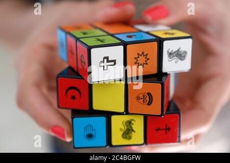 Donna con un cubo di rubik con simboli religiosi Foto Stock