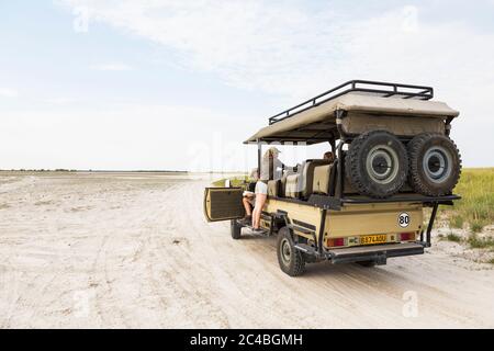 13 anni in pendenza su un veicolo safari, Botswana Foto Stock