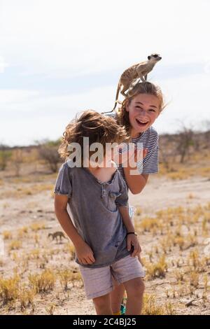 Ragazzo di 5 anni con Meerkat in testa, deserto di Kalahari, Saline di Makgadikgadi, Botswana Foto Stock