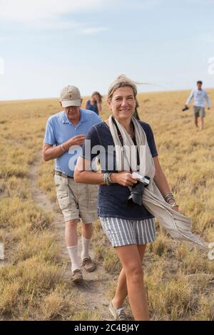 Famiglia che guarda Meerkats (Mongoose), deserto di Kalahari, Makgadikgadi Salt Pans, Botswana Foto Stock