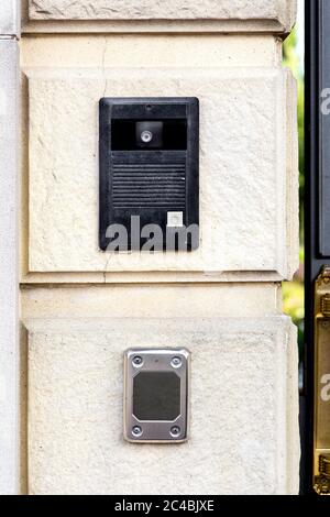 Un interfono con un pulsante di chiamata e una telecamera con un microfono su una parete di pietra con un rusticato sulla parte inferiore del lettore di schede per l'accesso. Foto Stock