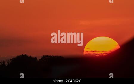 Wimbledon, Londra, Regno Unito. 25 giugno 2020. Dopo una giornata di temperature mediterranee, il sole tramonta dietro la collina di Wimbledon in cielo limpido in una serata calda e umida. Credit: Malcolm Park/Alamy Live News. Foto Stock