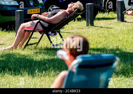 Una donna si bagna durante le condizioni soffocate a causa dell'alta umidità a Ijsselmeer nell'onda di calore come le temperature aumentano di nuovo a 30 gradi e sono le previsioni dicono che aumenterà più in alto i giorni seguenti. Foto Stock