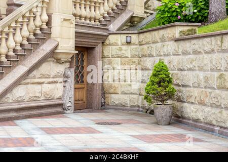 facciata dell'edificio esterna con elementi architettonici in stile decor in pietra con porta d'ingresso. Foto Stock