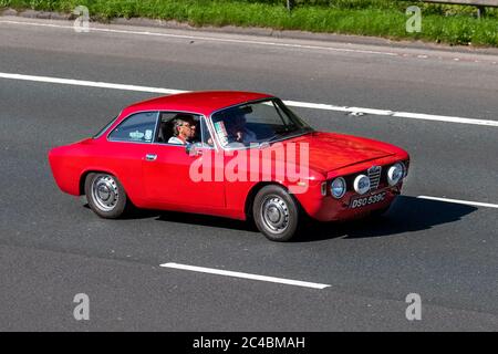 1965 rosso Alfa Romeo GT Junior 1.6; veicoli veicolari in movimento, auto in marcia su strade del Regno Unito, motori, motori sull'autostrada M6 Foto Stock