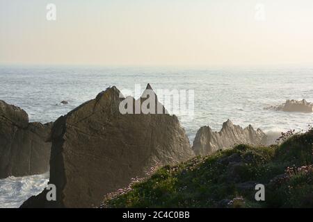 Scogliere rocciose e onde a Hartland Quay, North Devon, Regno Unito Foto Stock