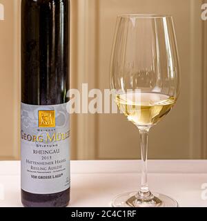 Una bottiglia di Riesling Auslese 2013 Hattenheimer Hassel, VDP.Grosse Lage (sito grand cru), dell’azienda agricola Georg Müller Stiftung, è posata accanto a un bicchiere di vino bianco all’Hotel e Restaurant Kronenschlösschen di Hattenheim, Eltville am Rhein, Assia, Germania. Nel 1913 Georg Müller lasciò la sua tenuta alla sua comunità natale di Hattenheim a condizione che i proventi andassero ai bisognosi. Peter Winter gestisce la tenuta dal 2003. L’Auslese fa parte dell’abbinamento vino-pietanza al pranzo di Maiorca dello chef stellato Michelin Marc Fosh (Restaurant Simply Fosh, Palma di Maiorca) il 26 febbraio 2017. Weinjournali Foto Stock