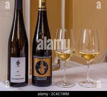 Due bottiglie di Riesling sono posate accanto a due bicchieri pieni nell'Hotel e Ristorante Kronenschlösschen di Hattenheim, Eltville am Rhein, Assia, Germania: 2015 Lorchhäuser Seligmacher dell'azienda vinicola Eva Fricke (a sinistra) e 2015 Frauenberg Riesling GG dell'azienda vinicola Battenfeld-Spanier (a destra). Entrambi i vini accompagnano il secondo piatto alla cena di gala dello chef stellato Michelin Nick Bril il 26 febbraio 2017, parte del 21° Rheingau Gourmet & Wein Festival: capesante con sorbetto al clementino, insalata di sedano e mela e vinaigrette al latticello. Hans Oliver Spanier presenta il Frauenberg, un VDP.Grosse La Foto Stock