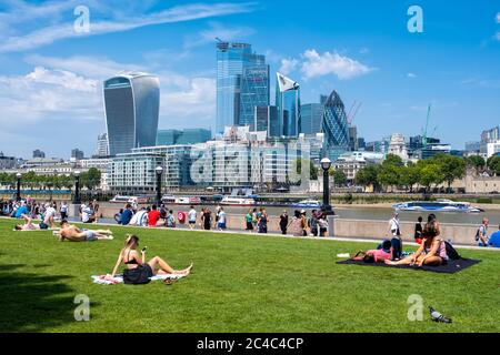 LONDRA, UK - LUGLIO 25,2019 : persone che godono l'estate vicino al Tower Bridge a Londra con una vista dello skyline della città Foto Stock