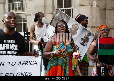 Londra, Regno Unito. 25 Giugno 2020. I manifestanti cantano canzoni durante la manifestazione. I manifestanti degli africani della ‘nella Diaspora si riuniscono fuori da Christie per chiedere il ritorno di manufatti africani. I musei europei stanno lottando per mantenere i manufatti africani mentre la pressione aumenta dagli attivisti. Credit: SOPA Images Limited/Alamy Live News Foto Stock