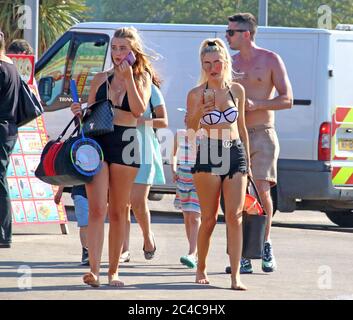 Skegness, Regno Unito. 25 Giugno 2020. La gente cammina verso la spiaggia il giorno più caldo dell'anno. La gente si dirige verso la spiaggia nella popolare località balneare di Skegness, come l'Inghilterra registra il suo giorno più caldo dell'anno con temperature a 30 gradi Celsius. Credit: SOPA Images Limited/Alamy Live News Foto Stock