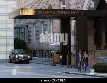 Trump International Hotel, Washington, D.C., USA, Capodanno 2019, con donna e uomo a piedi fuori; cameriere, Cadillac SUV in background Foto Stock