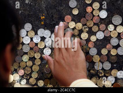 Chiang mai, Thailandia. 19 Nov 2009. Un adoratore mette una moneta ''fortunata'' su un muro al tempio Phra Tat Doi Suthep, il luogo sacro di culto buddista trovato sulla cima del monte Doi Suthep nella città settentrionale della Thailandia di Chiang mai, fondata nel 1386. Credit: Paul Lakatos/SOPA Images/ZUMA Wire/Alamy Live News Foto Stock
