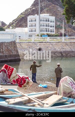 Mascate / Oman - 15 febbraio 2020: Pescatori con barche tradizionali nel villaggio di pescatori vicino al souk di Mascate Mutrah Souq Foto Stock