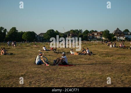 WIMBLEDON LONDRA, REGNO UNITO. 25 giugno 2020. Un grande gruppo di persone principalmente di giovani età si riuniscono durante una serata balsosa in bolle di divaricamento sociale su Wimbledon comune per bere e socializzare come le regole di blocco sono rilassati alla fine della giornata più calda in record a Londra. Credit: amer Ghazzal/Alamy Live News Foto Stock