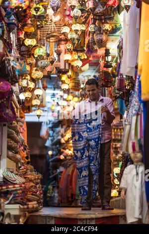 Mascate / Oman - 15 febbraio 2020: Venditore di souvenir come lampade e vestiti per i turisti Foto Stock