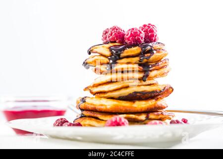 Deliziosi frittelle al formaggio di cottage con lampone fresco e un sorrup al cioccolato. Frittelle cagliate. Foto Stock