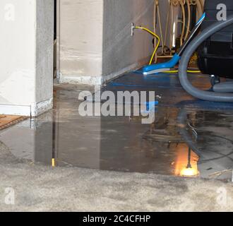 Danni causati dall'acqua al pavimento con attrezzatura di rimozione dell'acqua Foto Stock