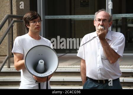 Ian Rintoul della Coalizione per l'azione dei rifugiati parla al raduno contro la deportazione di un richiedente asilo afgano. James flessibile tiene l'altoparlante. Foto Stock