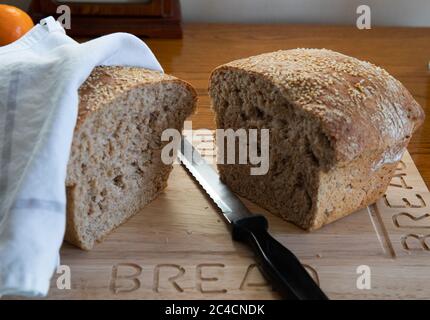 Pane integrale leggero cosparso di semi di Sesame su una tavola di legno Foto Stock