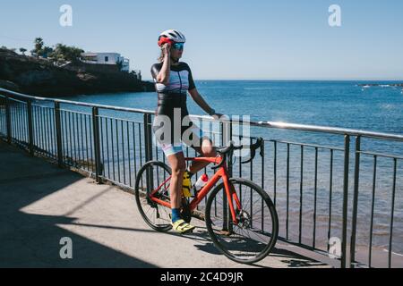 Ritratto di una giovane bella donna sorridente ciclista su una città di montagna Foto Stock