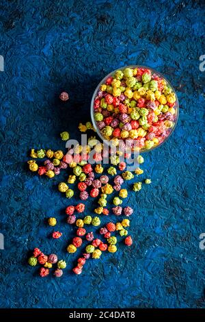 Popcorn colorato in scatola di carta su sfondo blu vista dall'alto Foto Stock