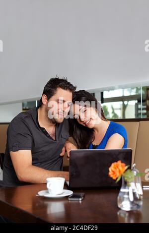 Coppia guarda un netbook nel caffè Foto Stock