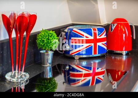 Primo piano del banco della cucina. Fornello a induzione. Tostapane e bollitore. Fiore verde. Interni moderni. Foto Stock