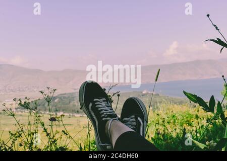 Primo piano dei piedi di una persona che indossa sneaker nere un bel campo Foto Stock