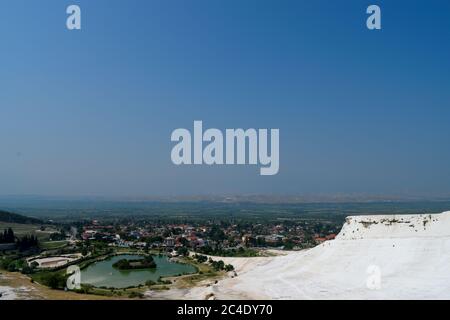 Vista della città di Pamukkale e del parco naturale di Pamukkale dalla cima delle sorgenti termali Foto Stock