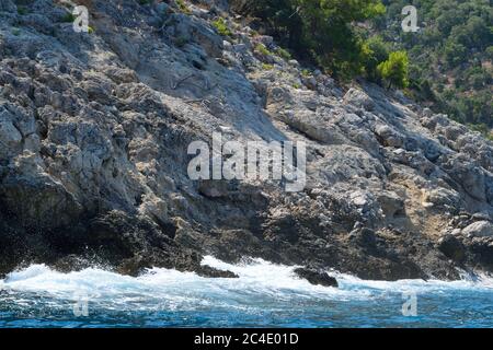 Una scogliera a Fethiye che si affaccia dal mare Foto Stock