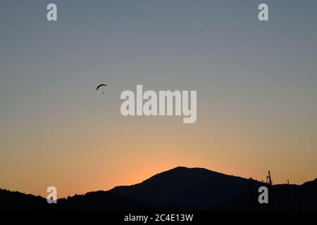 Un parapendio nel cielo sopra le colline a Oludeniz, Turchia Foto Stock