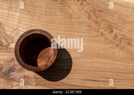 Tazza in legno retrò invecchiata per bere acqua latte bevande fredde e vino. Utilizzato anche per la misurazione di semole di zucchero di farina e grano su un offuscato Foto Stock