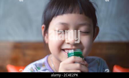 La bambina sta inalando felice il balsamo con sorriso e felice Foto Stock