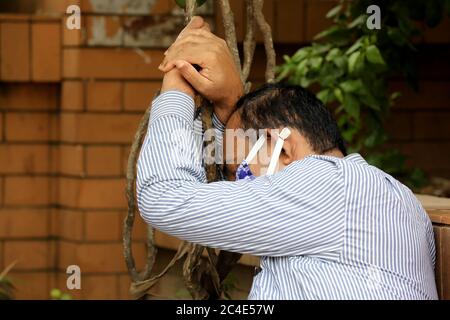 Dhaka, Bangladesh - 25 giugno 2020: Un uomo si trova sul terreno, come si sente malata dopo ore di attesa per Covid-19 test in un ospedale Mugda a Dhaka, Banglad Foto Stock