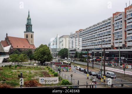 Vista degli edifici e del traffico lungo via Karl Liebknecht e la chiesa di Santa Maria dalla stazione di Alexanderplatz. Strada principale nel quartiere Mitte. Foto Stock