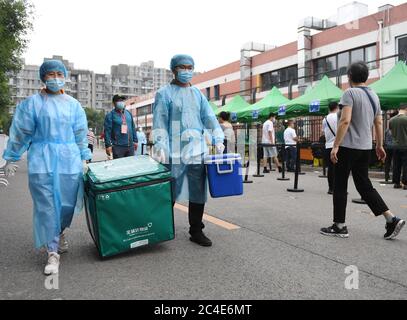 Pechino, Cina. 25 Giugno 2020. I membri del personale del trasferimento della Diagnostica KingMed hanno raccolto campioni per il test degli acidi nucleici nel distretto di Chaoyang di Pechino, capitale della Cina, 25 giugno 2020. Con 2,422 punti di raccolta dei campioni in 480 sedi in tutta la capitale, Pechino può ora offrire più di 300,000 test di acido nucleico per COVID-19 ogni giorno. Credit: Zhang Chenlin/Xinhua/Alamy Live News Foto Stock