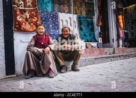 Leh , Ladakh region , India - 20 agosto 2016: Old Ladakhi gente coppia venditori di tappeti seduti sulla strada a Leh, India Foto Stock