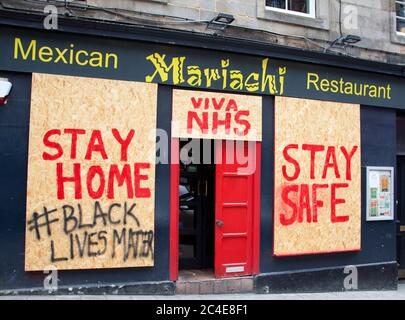 Edimburgo, Scozia, Regno Unito. 26 giugno 2020. Alcuni pub e ristoranti del centro città sono ancora imbarcati come erano all'inizio della crisi pandemica in Scozia, ma altri stanno mostrando alcuni segni di vita come la pittura e la decorazione e forse modifiche per soddisfare le nuove esigenze di allontanamento sociale. Nella foto: Ristorante messicano Mariachi in Victoria Street, che ha la porta socchiusa ma i nemici si sono imbarcati. Foto Stock