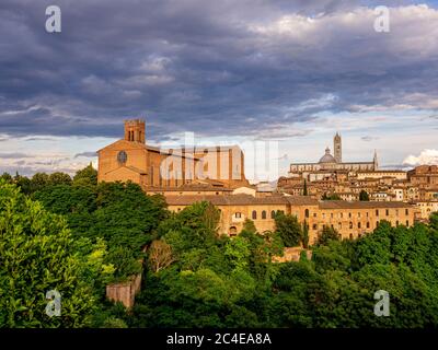 Cattedrale di Siena con la Basilica di San Domenico a sinistra e la Scuola d'Arte di Duccio in primo piano. Italia Foto Stock