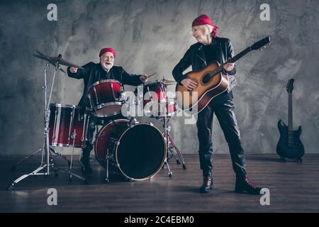 Foto a lunghezza intera della band rock uomo di signora in pensione eseguire concerto suonare strumenti a tamburo chitarra acustica famiglia indossare abiti alla moda in pelle basculante Foto Stock