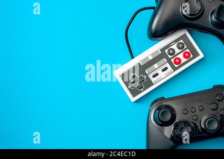 Tema di concetto di console di gioco e giochi per computer con controller di videogiochi isolati su sfondo blu con spazio di copia Foto Stock