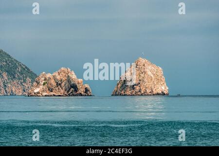 GURZUF, CRIMEA - Vista da una spiaggia in Gurzuf sulle famose rocce Adalary, due doppie-scogliere con un bordo di montagna Au-Dag in primavera mattina presto a. Foto Stock