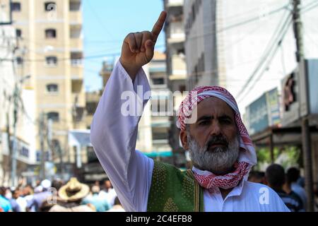 26 giugno 2020: Gaza, Palestina. 26 giugno 2020. I palestinesi si uniscono a un raduno di massa a Khan Yunis, nella striscia di Gaza meridionale, in opposizione al 'Seal of the Century' del presidente Trump e al piano di Israele di confiscare terra in Cisgiordania. Israele sta progettando di estendere la propria sovranità a quasi il 30 per cento della Cisgiordania, compresi più di 230 insediamenti israeliani e la Jordan Valley, con il sostegno dell'amministrazione statunitense. Secondo il diritto internazionale, la Cisgiordania è un "territorio occupato" e la sua annessione è una grave violazione della carta delle Nazioni Unite e della stessa Foto Stock